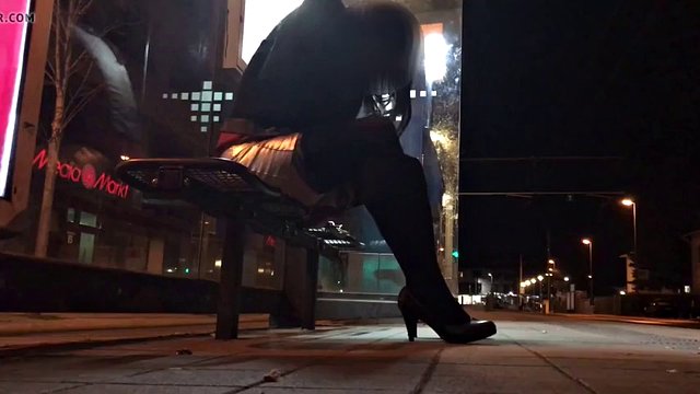 Crossdresser fixed on a bench in a tram station