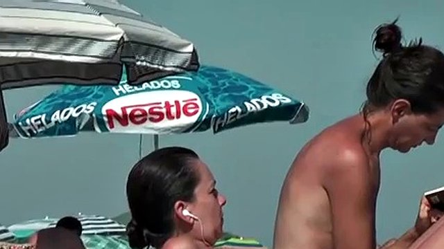 Bitch on the beach wetting her horny nudist pussy