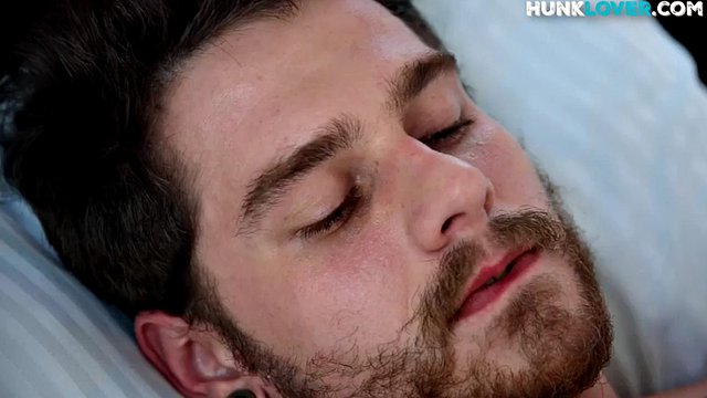 Close-up bearded hunk jerking off his cock during solo on the bed