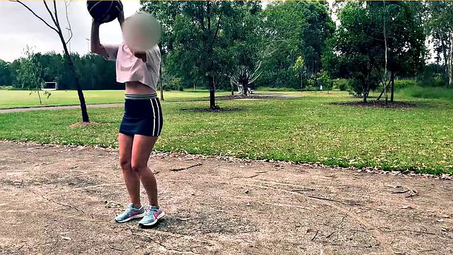 La mujer se atreve a jugar al baloncesto sin sujetador y bragas con falda corta.